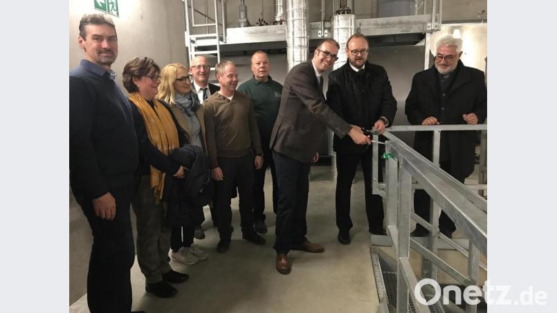 Landrat Andreas Meier und der EDL-Geschäftsführer Dr. Carsten Schaefer (Zweiter und Dritter von rechts) durchschneiden das Band zur Treppe in die Tiefen des Heizwerks. Bürgermeister Rupert Troppmann (rechts), der Naturenergie-Geschäftsführer Hans-Peter Lang (Vierter von rechts) und die Schulleiter beobachten den offiziellen Akt. . Bild: eig