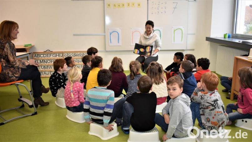 Tan Hu, eine Schülermutter, trägt beim Vorlesetag in den Sprachen Deutsch, Englisch und Chinesisch eine Bilderbuchgeschichte vor. Bild: rgr