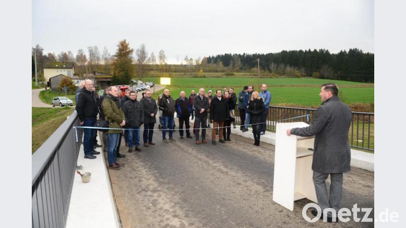Bürgermeister Rainer Rewitzer (rechts am Pult) freut sich bei der offiziellen Einweihung der Brücke über die Pfreimd, das die Kostenschätzung mit den tatsächlichen Kosten übereinstimmt. Bild: bey