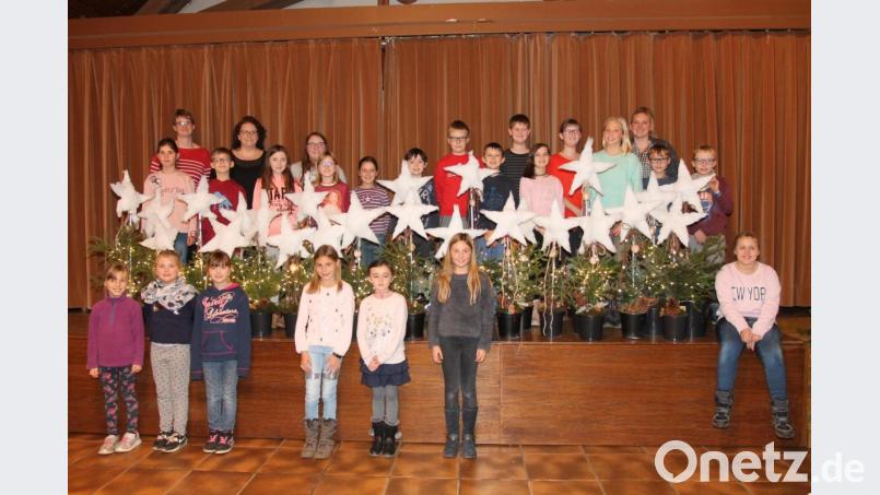 Julia Helgert (hinten, Zweite von links) freut sich mit ihrem Team und den Kindern über die Kunstwerke. Bild: pi