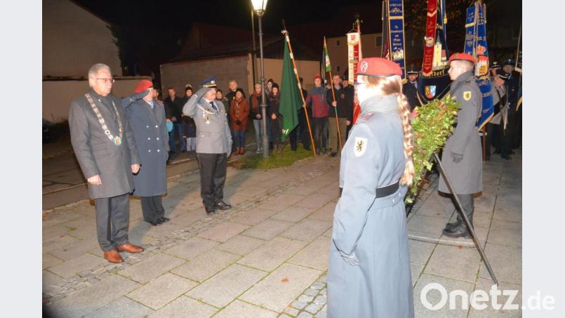 Bürgermeister Josef Hammer, Hauptmann Claudia Kolodinski und der Vorsitzende der Soldatenkameradschaft, Mario Rössler legen einen Kranz am Kriegerdenkmal nieder. Bild: fz
