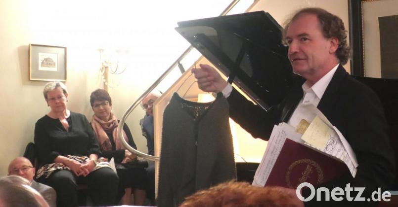 Pianist Stefan Mickisch zeigte den Zuhörern die Strickweste, die er bei seinem ersten Auftritt vor 50 Jahren trug. Am Freitag eröffnete er in seiner Villa die Veranstaltungsreihe zum Bühnenjubiläum. Bild: Hirsch