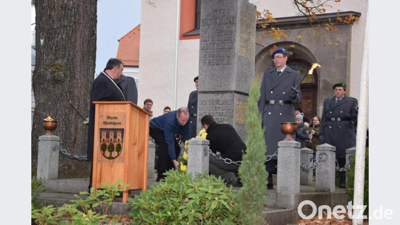 Zum ehrenden Gedenken legten die Markträte Georg Bocka (li) und Georg Stahl (re) eine Kranz am Denkmal nieder. Bild: fla