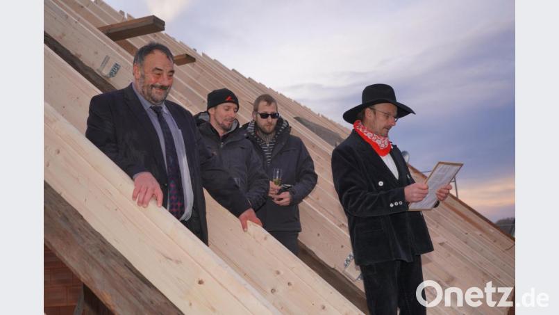 Obwohl Bürgermeister Josef Beimler beim Richtfest etwas nass wird, folgt er dem Richtspruch des Zimmerermeisters Josef Bodensteiner (rechts) aus Obertresenfeld. Bild: fvo