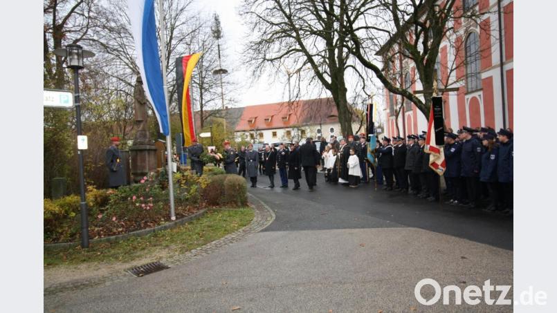 Geste der deutsch-amerikanischen Freundschaft bei der Kranzniederlegung: Major Denny Ziegert (2. Artilleriebataillon 131), Bürgermeister Albert Nickl, Colonel Jason Caldwell (US-Einheit JMSC aus Grafenwöhr) und Max Wagner, der Vorsitzende der Soldatenkameradschaft, treten gemeinsam vor das Gefallenen-Ehrenmal. Bild: bjp