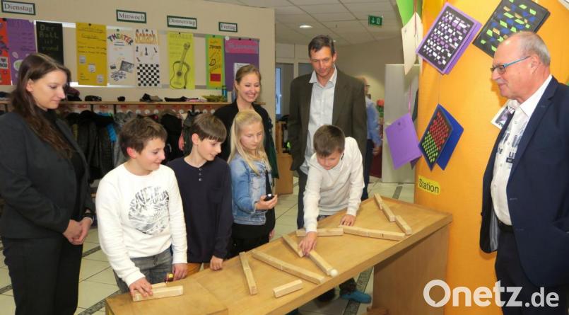 Johanna Schneider, Doreen Dambacher, Thomas Rauch und Hubert Döpfer (von links) schauen den Kindern beim Experimentieren an einer schiefen Ebene über die Schultern. Bild: Hirsch