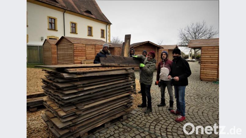 Mit Hilfe der Migranten hat der neue Weihnachtsmarktorganisator, Dominik Neitz (re.) alles im Griff. Die Buden stehen, jetzt wird die Deko angebracht. Bild: ubb