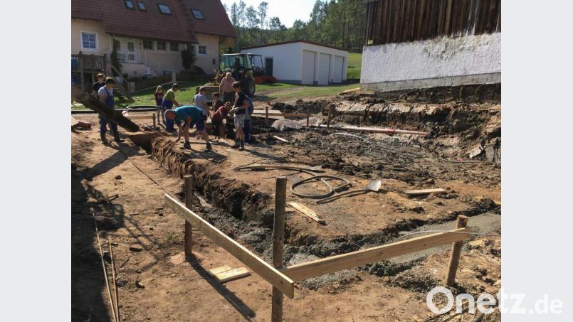 Nachdem Christian Riß das Grundstück im Ortskern zur Verfügung gestellt und Bauunternehmer Sepp Falk die Planung für das Gemeinschaftshaus entworfen hat, beginnen im September 2018 die Baumaßnahmen mit dem Erdaushub, dem Einbringen einer Bodenplatte und dem Errichten einer Stützmauer. Dabei packen Jung und Alt an. Bild: u