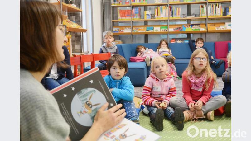 Die Kinder lauschen in der Regional-Bibliothek gespannt einer Kindergeschichte. Bild: Gabi Schönberger