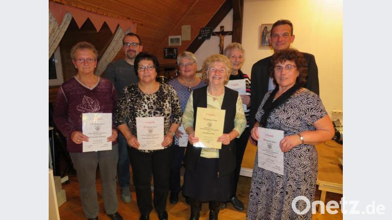 Mit Urkunden zeichnet Peter Aichholzer (hinten, links) langjährige Mitglieder und Aktive aus. Bürgermeister Ernst Schicketanz (hinten, rechts) gratuliert. Bild: adj