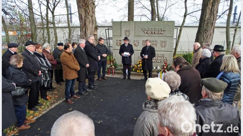 Der Verstorbenen der Vertreibung und Flucht gedenken am Vertriebenenmahnmal Rainer Wagner (links am Gedenkstein) und Norbert Uschald (rechts daneben) am Totensonntag mit den Vertretern der Landsmannschaften und Mitbürgern. Bild: Dobmeier