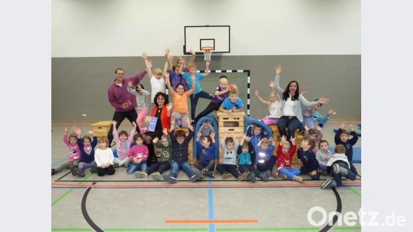 Das Bild zeigt einen Teil der Kinder mit den Vorlesepaten Ulrik Katholing, Michaela Härtl und Margit Bayer in der neuen Sporthalle. Bild: fpoz