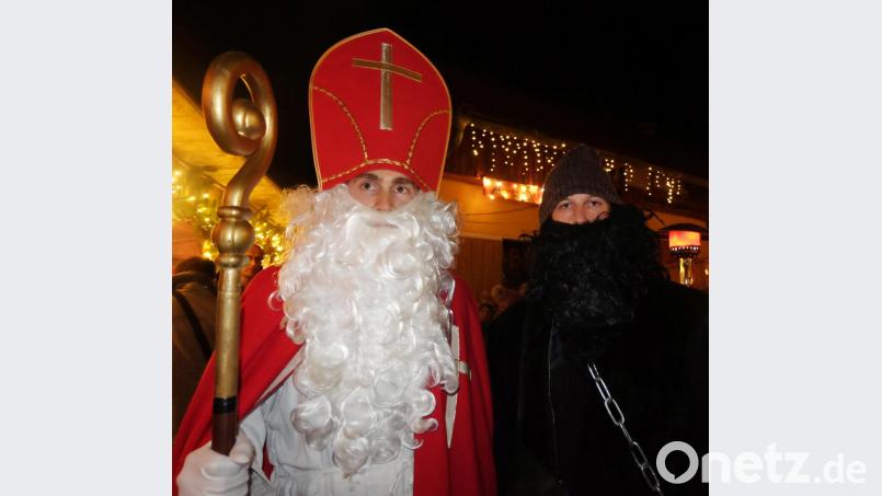 Der Nikolaus und sein Knecht zwängen sich durch die dichten Reihen und verteilen Süßes an die Kleinen. Bild: ohr