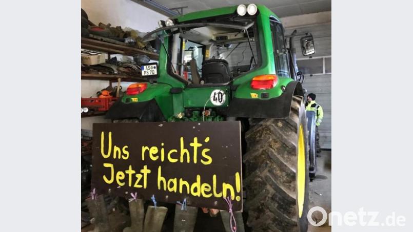 Gummistiefel baumeln an dem Schild, das Herbert Schmidt aus Nitzlbuch an seinen Traktor geschraubt hat. Bild: Herbert Schmidt