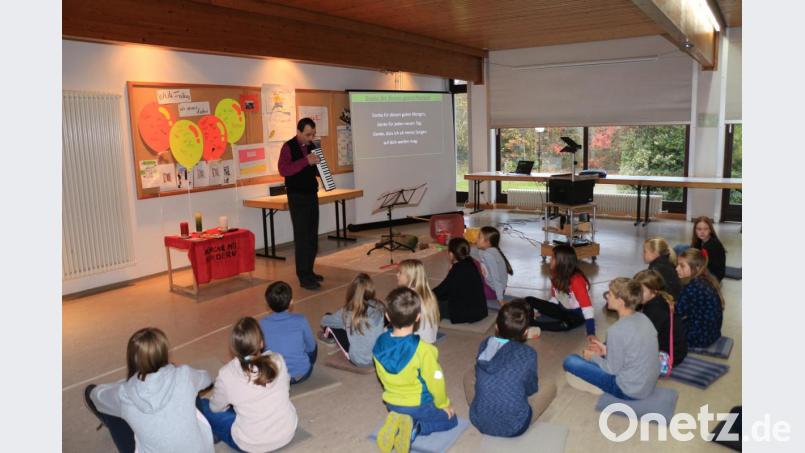 Pfarrer Hartmut Klausfelder begrüßt die Kinder mit einigen „Schlagern“ aus Kindergottesdienst und den vergangenen Kinderbibeltagen. Bild: rpp