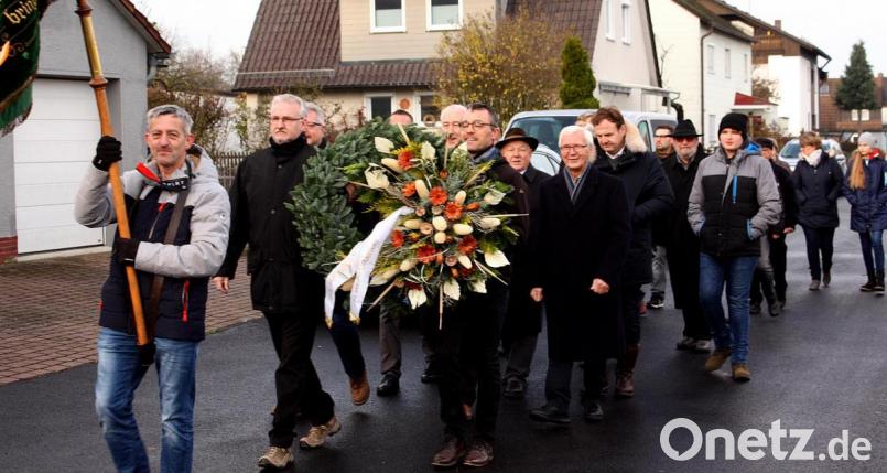 Mit einem Schweigemarsch durch den Ortsteil errichten die Menschen den Gedenkstein, die Fahne der Siedlergemeinschaft geht voran. Bild: R. Kreuzer