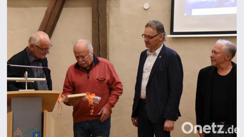 Mit einem von ihm gemalten Bild des Schnaittenbacher Bahnhofs bedankte sich Jürgen Hartmann (Zweiter von links) für den Arbeitskreis Heimat und Kultur bei Klaus Tschierschke (links). Heinz Steinkohl (rechts) organisierte den Abend und Markus Nagler moderierte. Bild: nag