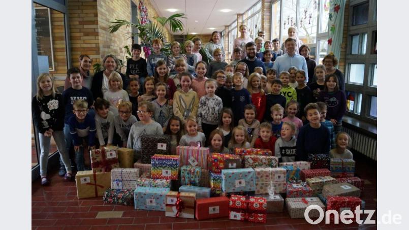 42 Weihnachtspäckchen für notleidende Kinder in Osteuropa übergeben die 60 Schirmitzer Grundschüler den Vertretern von Round Table Weideni. Bild: du