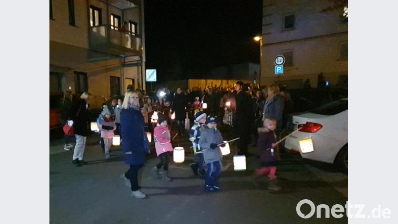 Mit selbst gebastelten Laternen ziehen die Mädchen und Buben von der Kirche zum Kindergarten. Bild: exb/Katharina Pfistermeister