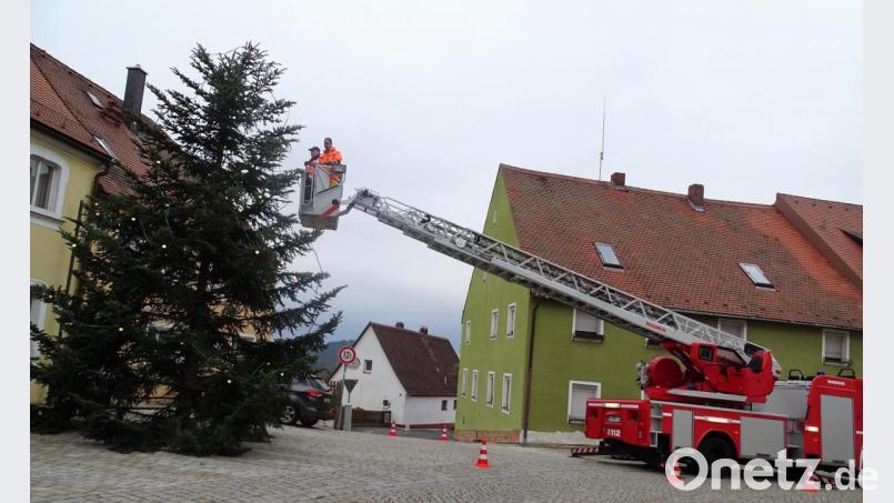 Mit ihrer Drehleiter war die Kemnather Feuerwehr angerückt, damit die Lichterketten am Waldecker Christbaum angebracht werden konnten. Bild: luk
