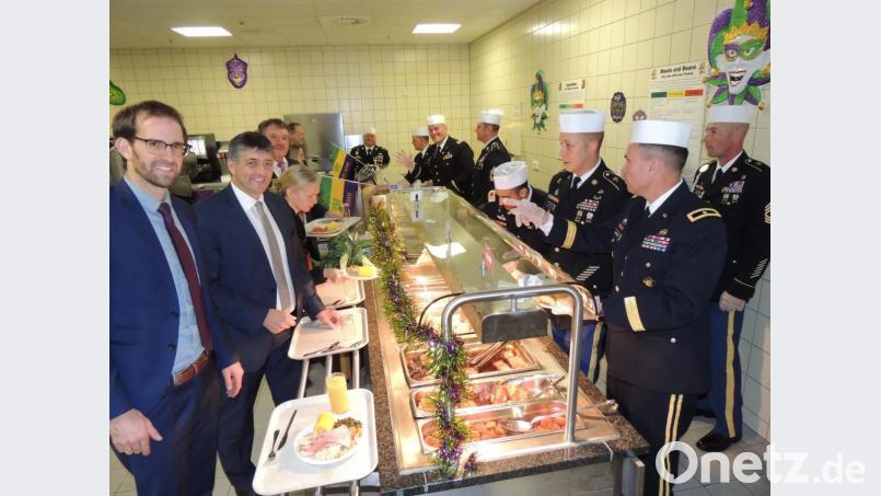 Was darfs sein? General Christopher R. Norrie (Zweiter von rechts) bei der Essensausgabe Bild: mor