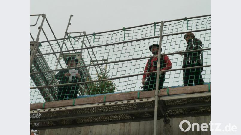 In luftiger Höhe: Die Zimmerei Streck befestigte den mit gelben Bändern geschmückten Richtbaum an einem Balken. Bild: Portner