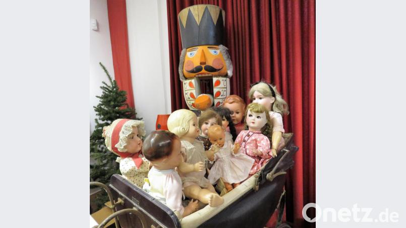 Hinter den netten Porzellanpuppen schaut der wohl größte Nussknacker aller Zeiten hervor. Auch er hat einen schönen Platz in der Ausstellung bekommen. Bild: ubb