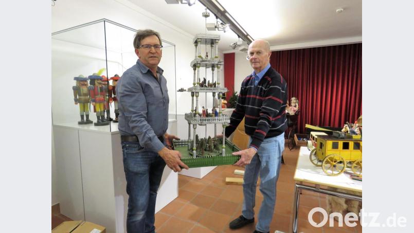 Museumsmitarbeiter Hans Enslein (links) hilft Helmut Weiß beim Tragen der großen Weihnachtspyramide. Bild: ubb