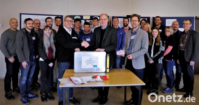 Das Lean-Spiel aus Mitterteich nimmt Robert Köhler (BHS) von Standortleiter Stefan Rosner (vorne, von links) entgegen. Die Vertreter vieler namhafter Firmen der Region sind dabei. Bild: exb