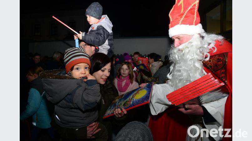Nikolaus verteilt vor dem Landricherschloss an die Kinder Adventskalender. Bild: bey