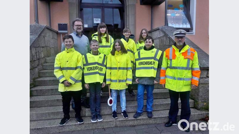 Rektor Thomas Bodensteiner (links) und Polizeihauptkommissar Simon Christian (rechts) freuen sich, dass neue Schülerlotsen ein wachsames Auge auf ihre Mitschüler haben. Bild: jma