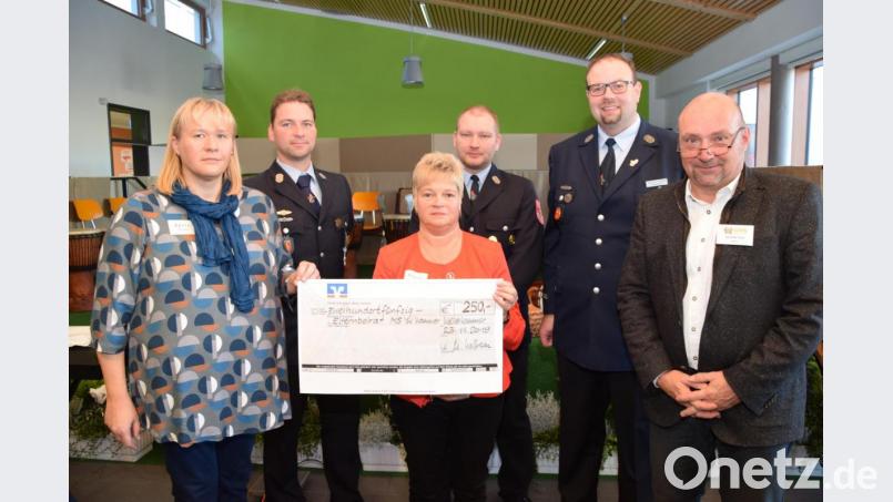 Die Vertreter der Feuerwehr geben dem Elternbeirat 250 Euro. Rektor Günther Paul (rechts) freut sich auch. Bild: fz
