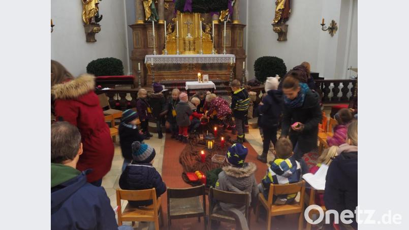 Die Kinder legen ihre Herzen rund um den Stall am Altar ab. Bild: stn