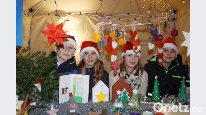 Kinder mit Nikolausmützen verkaufen Spiel- und Bastelsachen und spenden den Erlös für das Tierheim in Weiden Bild: du
