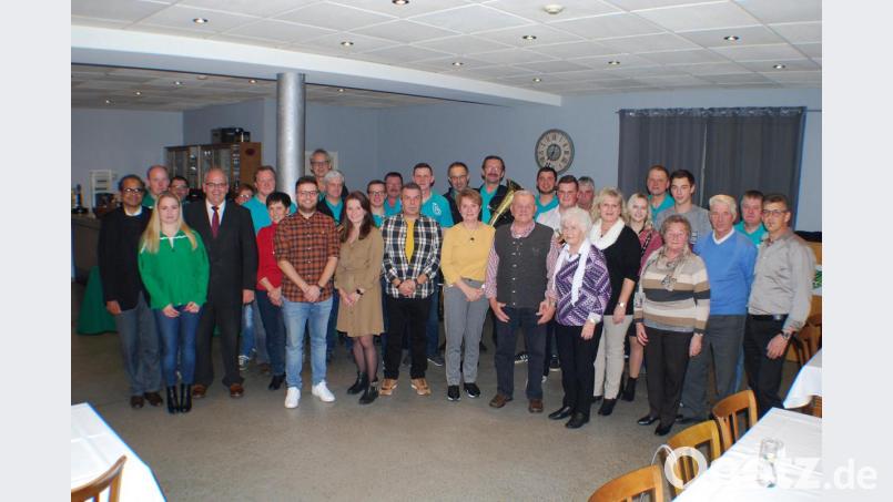 Hugo Ulrich (13. von rechts) feierte seinen 80. Geburtstag im Gasthaus &quot;Zum Tillenblick&quot; mit seiner Ehefrau, seinen Kindern und Enkelkindern sowie Pfarrer George Parankimalil, TSV, Blaskapelle Ernestgrün, Bürgermeister Klaus Meyer sowie Edeltraud Köstler von der Pfarrei. Bild: enz