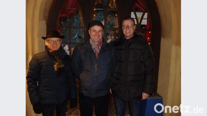 Bürgermeister Hermann Falk (rechts) öffnet das erste Türchen des 19. Lebendigen Adventskalenders. Er dankt allen, die zum Gelingen der Veranstaltungsreihe beitragen. Gewerbeverbandsvorsitzender Alfred Härtl (links) weist auf die Spendenbox hin, deren Inhalt für den Hospizverein Amberg bestimmt ist. Mit dabei stellvertretender Vorsitzender Gaston Lottner vom Heimat- und Trachtenverein, dessen Mitglieder allabendlich die kulinarische Versorgung der Besucher übernehmen. Bild: u