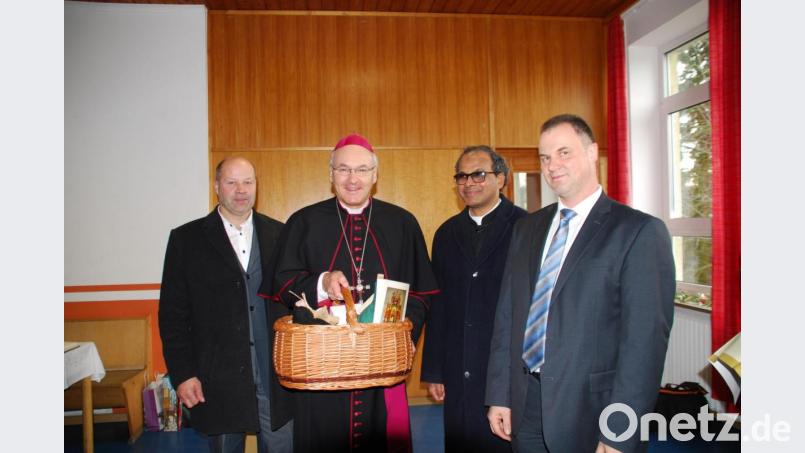Bischof Voderholzer erhielt durch Pfarrgemeinderats-Sprecher Stephan Forster (rechts) und Kirchenpfleger Josef Altnöder (links) einen Korb mit regionalen und selbstgebastelten Geschenken Bild: enz