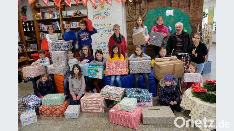 Ddie spendenfreudigen Schulkinder stellen sich mit Schulleiterin Gabriele Bodner (Bildmitte) bei der Übergabe der vielen großen und kleinen Weihnachtspäckchen an Hans Karl (Zweiter von rechts) für ein Foto auf. Bild: do