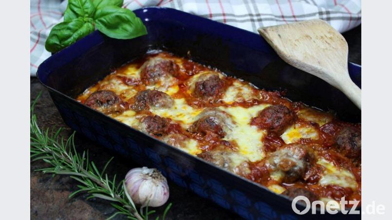 Die Hackbällchen sollten ein wenig aus der Tomatensoße ragen, wenn sie in den Ofen kommen. Nach der Garzeit für das Fleisch kommt der Mozzarella zum Überbacken darüber. Bild: Matthias Würfl