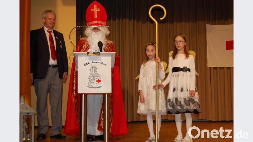 Sankt Nikolaus (Josef Schweiger) und seine Engel Amelie und Melina überraschen die Gäste in der BRK-Adventfeier. Bild: az