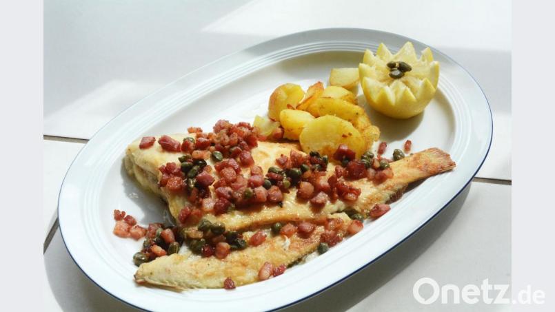 Mit knusprigem Speck und Kapern in zerlassener Butter wird die Scholle Finkenwerder Art serviert. Dazu passen Bratkartoffeln und ein Salat. Bild: Gabi Schönberger