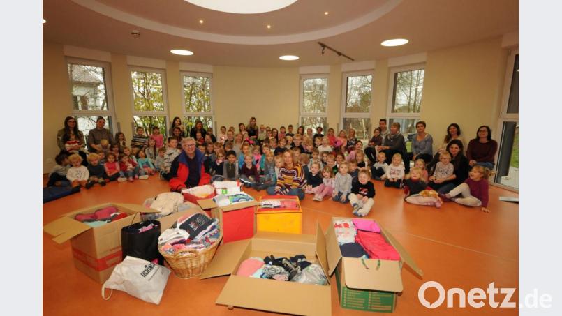 Integrationsbeauftragter Manfred Weiß (vorne, links) freut sich über den Einfall von Kinderhausleiterin Jutta Kellner (vorne Mitte), die Idee des St. Martin vom Teilen mit einer Kleidersammlung umzusetzen. Bild: bey