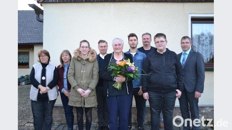 Hilde Knoblach (mit Blumenstrauß) feiert mit der Familie 80. Geburtstag. Dazu gratulieren auch Bürgermeister Hermann Ach (rechts) und Pfarrer Dieter Schinke aus Vohenstrauß (Vierter von links). Bild: gi
