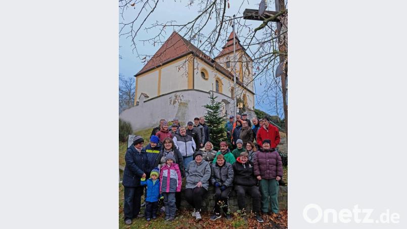 Bürgermeister Konrad Kiener (hinten links neben dem Baum), Mesner Hans Wagner, Pfarrer Markus Ertl, Initiatorin Maria Schlögl (hinten rechts neben dem Baum) freuen sich mit den Oberköblitzer Bürgern und Mitarbeitern der Werkstätten von Dr. Loew Soziale Dienstleistungen über die Gemeinschaftsaktion. Bild: twi