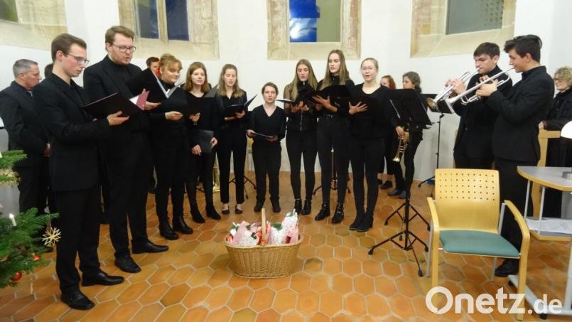 Blechbläser und Vokalisten zusammen auf der Bühne der Schloss-Kapelle. Im Korb vor ihnen &quot;Nikolaus-Packerln&quot; als Dankeschön des Museums-Fördervereins. Bild: hka