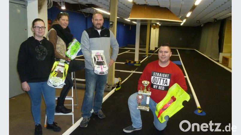 Ein Familienteam: Michael Reisinger kann beim Aufbau der Rennbahn im ehemaligen Ladengeschäft Rossmann auf die Unterstützung von Gattin Isabell und den Kindern Maverick (mit Deutscher-Meister-Pokal) und Kira zählen. Sie alle fiebern der Eröffnung am Christkindlmarkt, 7. Dezember, entgegen. Bild: Portner