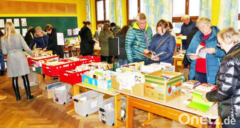 Zahlreiche Besucher durchstöbern beim Bücherflohmarkt in der Kirchenthumbacher Grundschule die Kisten. Bild: ü