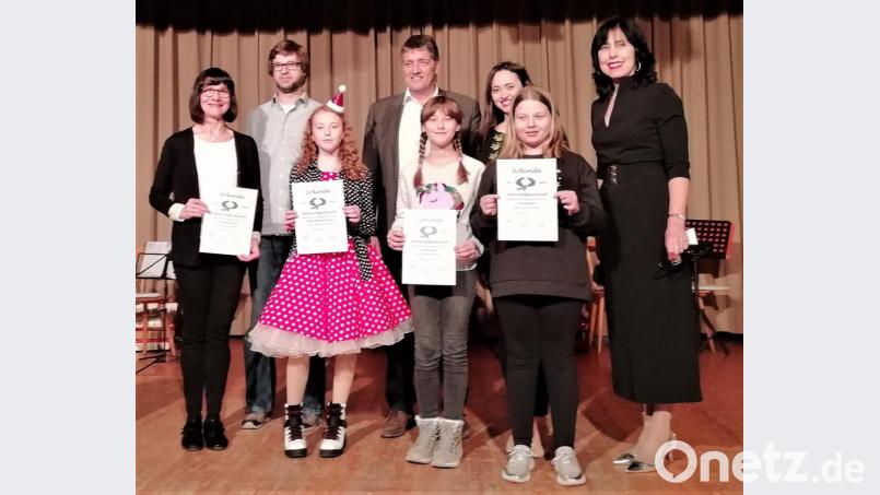 Vorsitzende Lilia Gette (rechts) überreicht einigen jungen Musikern Urkunden für fünf und 15 Jahre Musizieren im Verein. Bürgermeister Edgar Knobloch (Mitte) und die Musiklehrer gratulieren. Bild: rgr