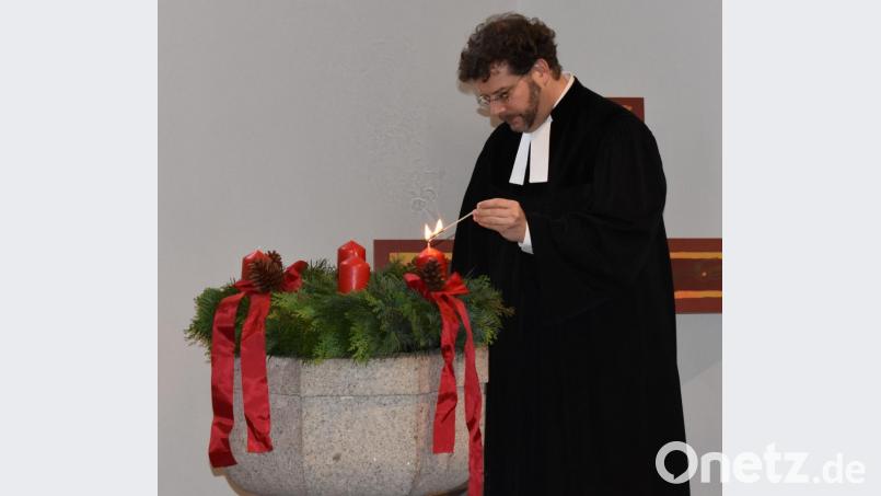 Pfarrer André Fischer zündet am Beginn des neuen Kirchenjahres die erste Kerze am Adventkranz an. Bild: rgr