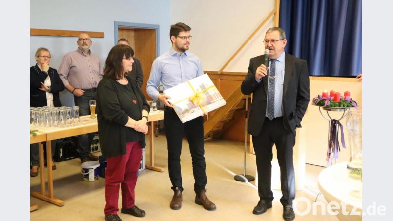 Der Sprecher des Pfarrgemeinderates Simon Mauerer (Mitte) überreicht mit Stellvertreterin Anita Weiß-Müller (links) im Namen der Kirchenverwaltungen und des Pfarrgemeinderats der Pfarreiengemeinschaft ein Präsent: Ein Adventskalender der Elbphilharmonie mit Zuschuss zu einer Fahrt dorthin. Helmut Wolf (rechts) dankt. Bild: wrm